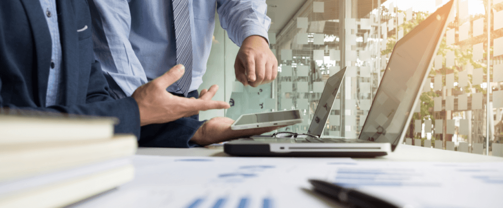 Dois homens apontando para um computador