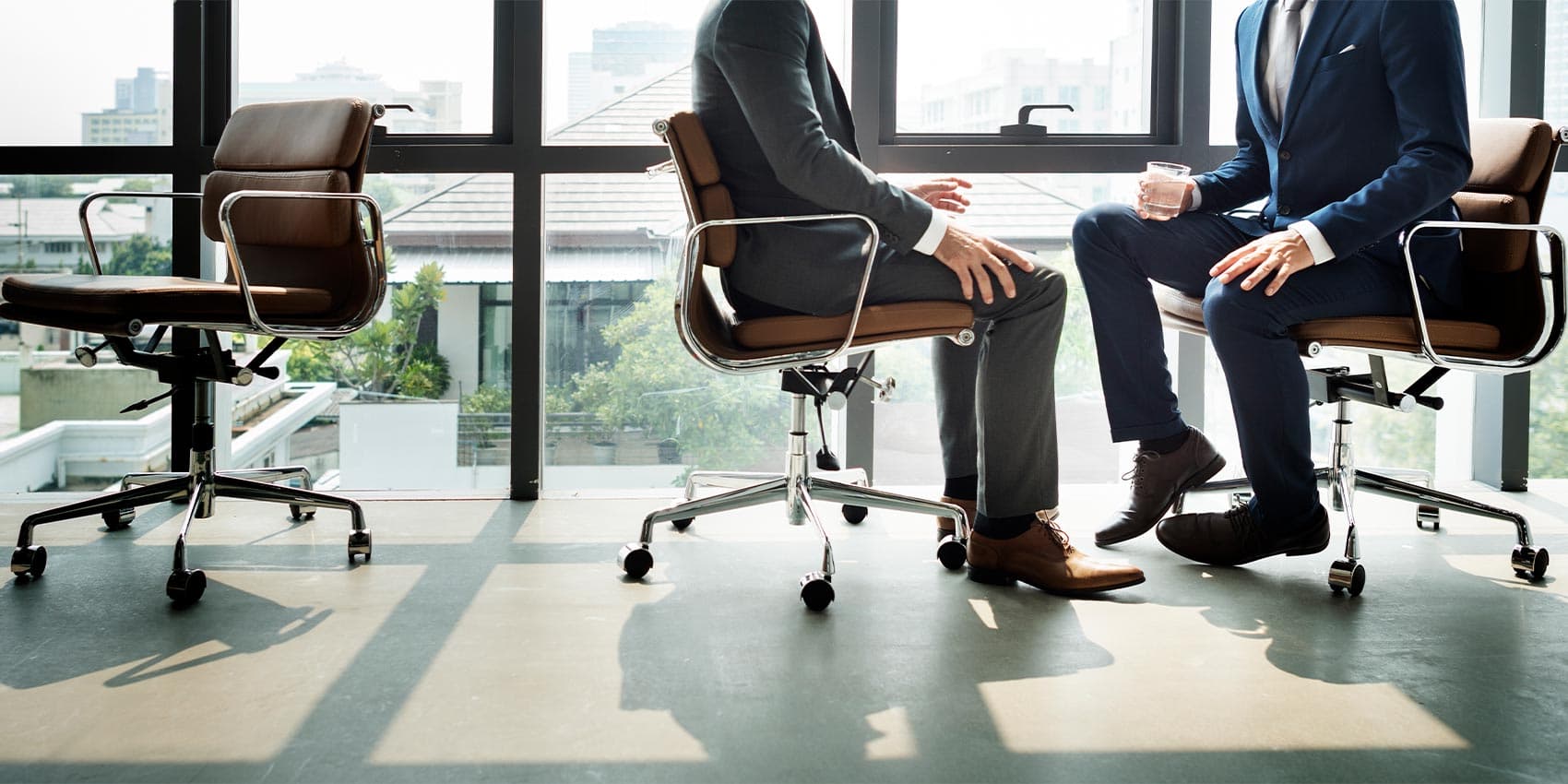 Dois homens sentados em uma cadeira de escritório